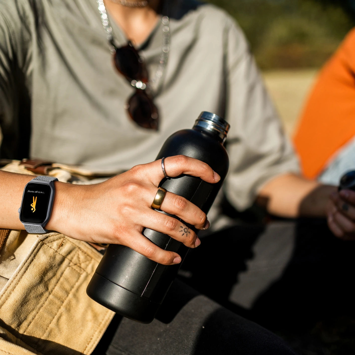 A man wearing The Trevit Smartwatch and holding a water bottle