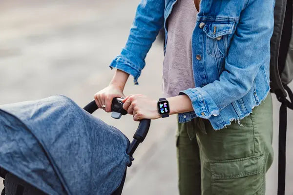 A mother pushing a stroller wearing The Trevit Smartwatch
