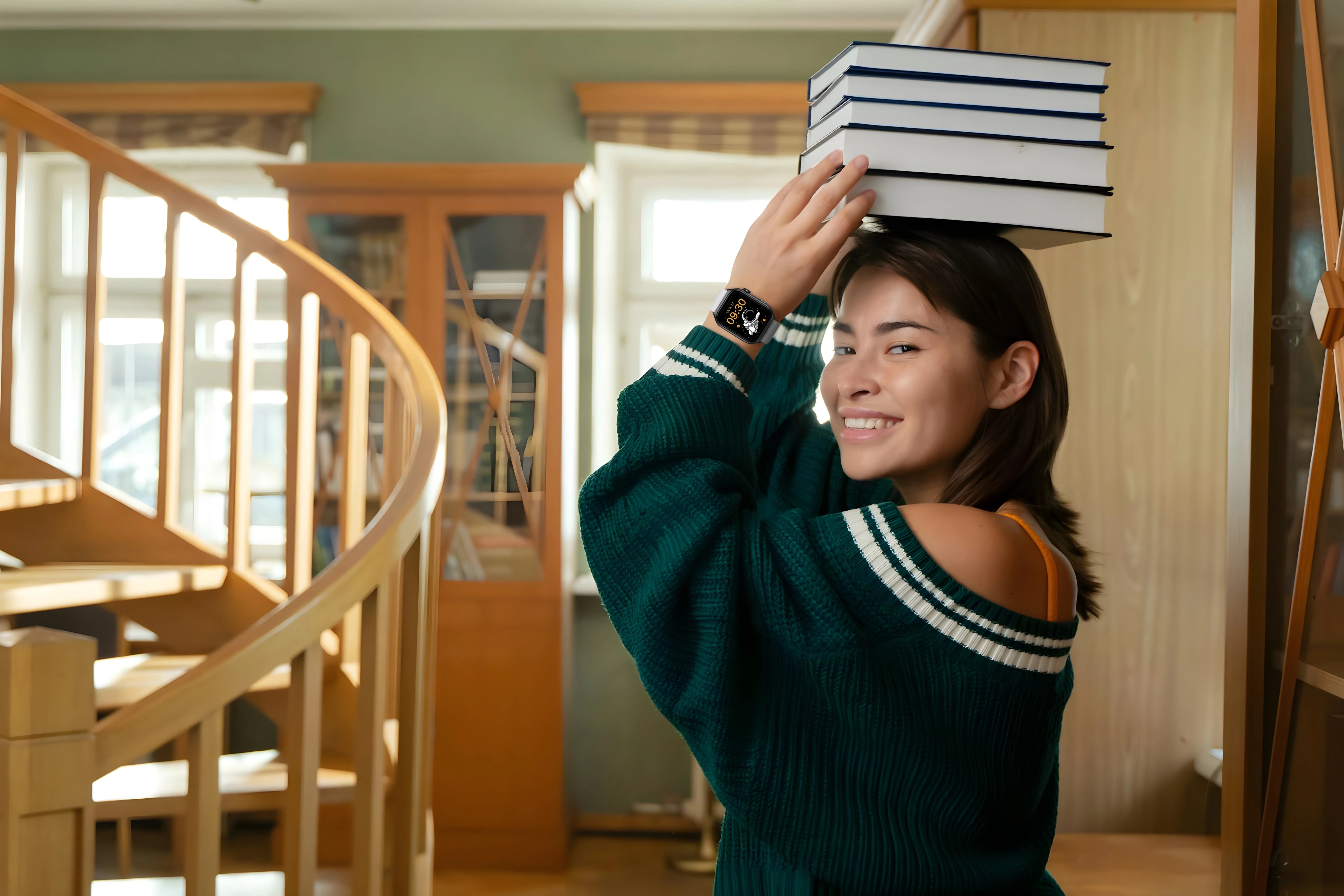 A university student with books stacked on her head and wearing The Trevit Smartwatch
